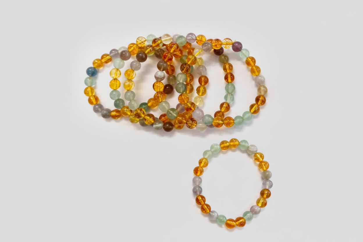 A collection of colorful bracelets made from beads, presumably containing multi-fluorite and citrine as described in the product description.