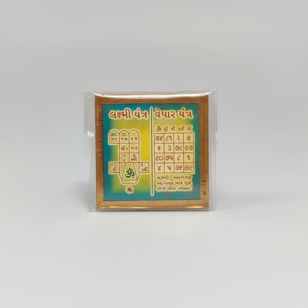 A hand holding a Laxmi Business Yantra, which is a colorful geometric sacred geometry design on paper.
