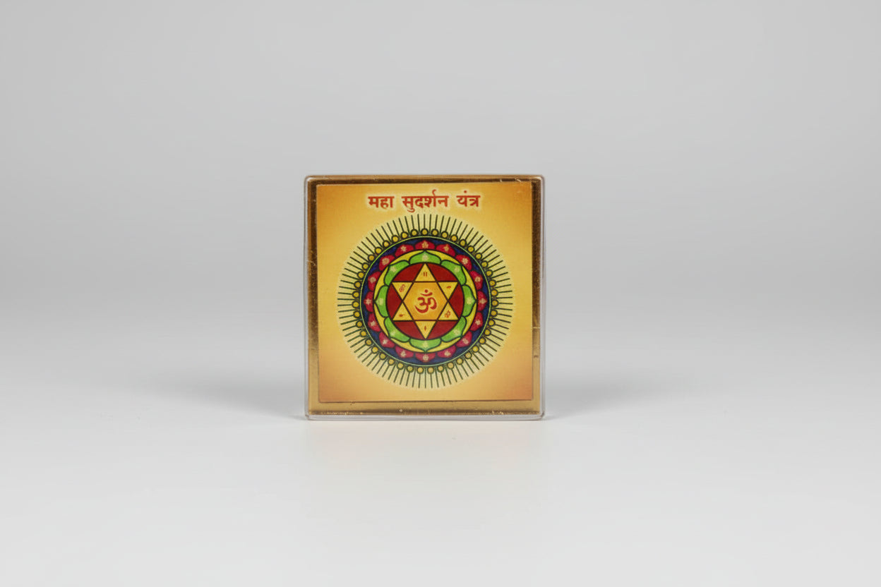 A hand holding a Maha Sudarshan Yantra, which is a spiritual tool with a geometric pattern and sacred geometry symbols in vibrant colors.