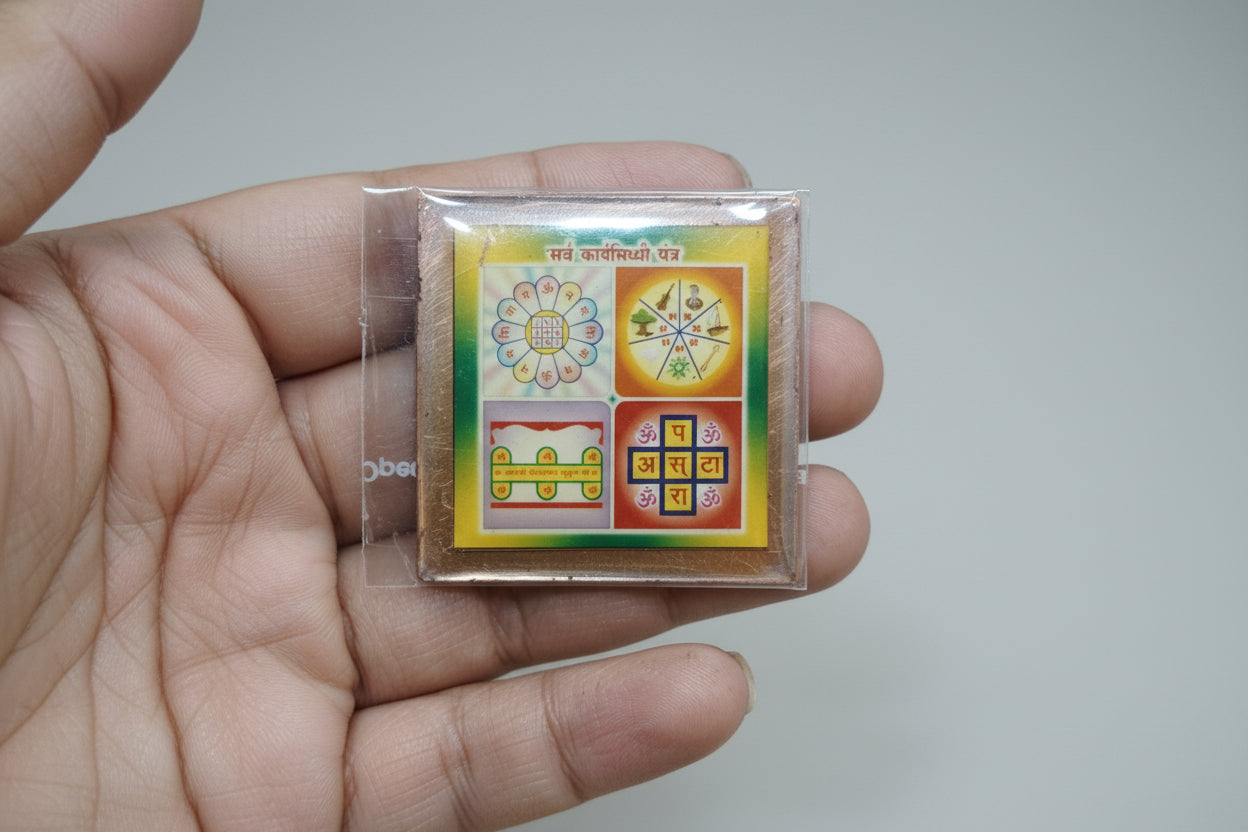 A colorful Sarv Karya Siddhi Yantra held in a person's hand, featuring geometric and floral patterns on a square card.