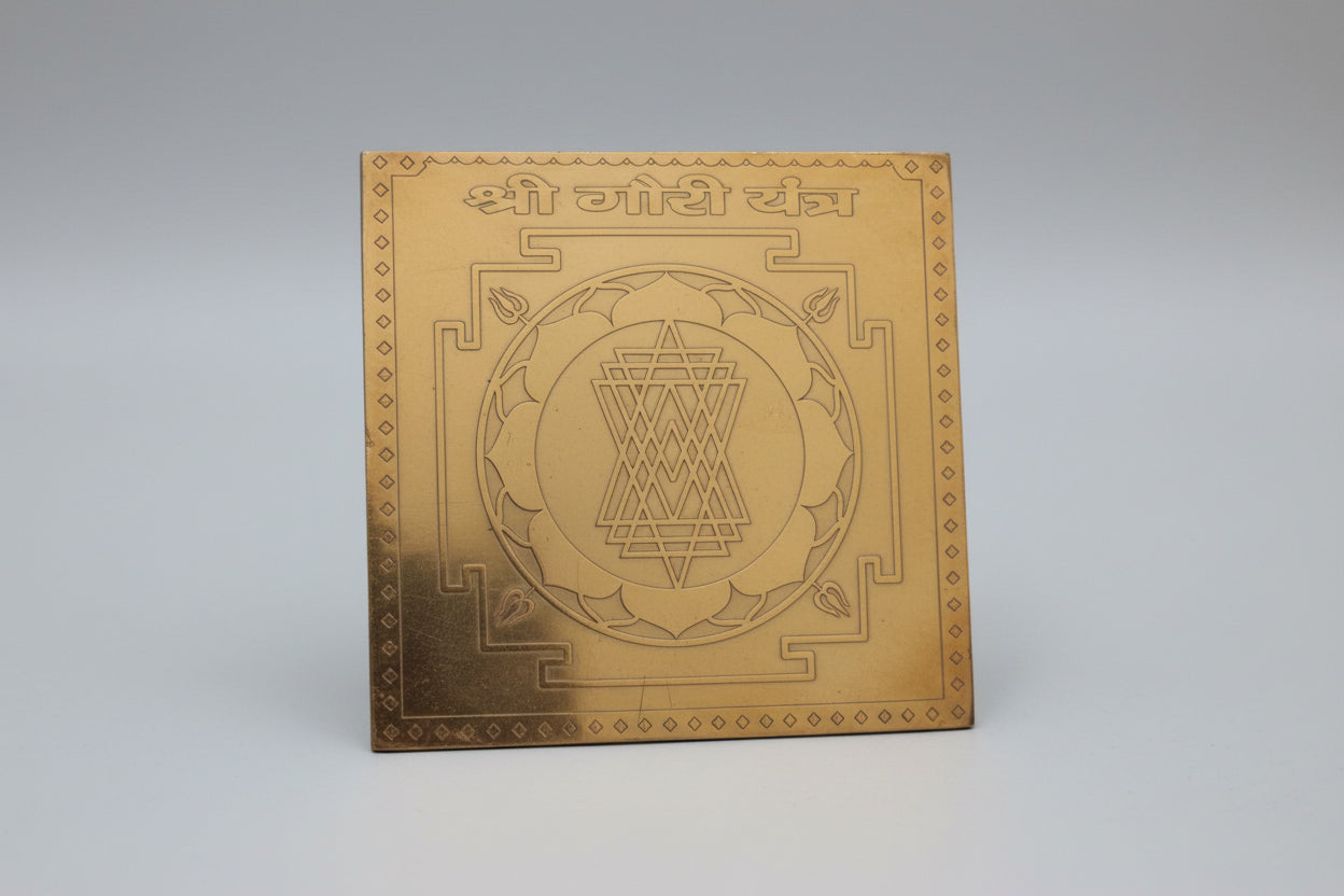 A sacred geometric diagram, yantra, engraved on a copper plate, kept vertically oriented.
