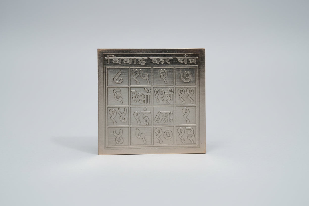 A silver-colored metal plate with embossed geometric patterns, likely representing the Vivah Kar Yantra.