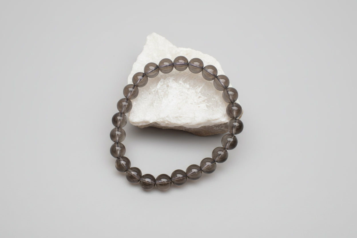 A smokey quartz bracelet displayed on a white surface with the name 'Smokey quartz bracelet' and a price tag of 650 rupees.
