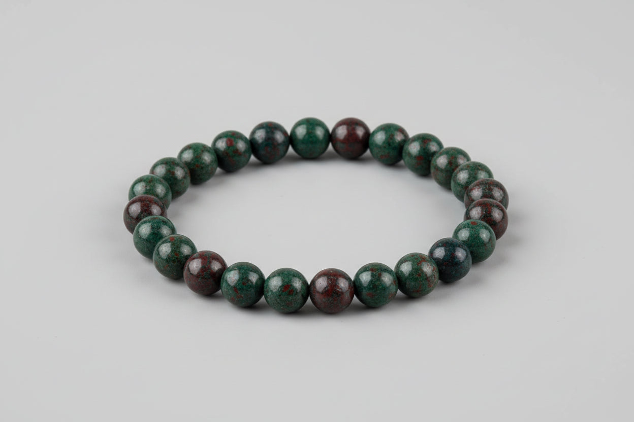 A Bloodstone bracelet displayed against a white background with floral patterns, emphasizing the bracelet's colors and its promotional benefits of purification, health, and organization.