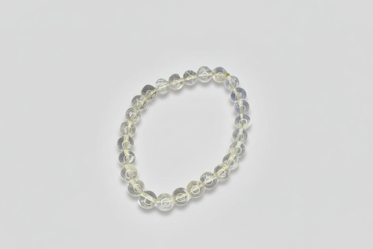 A promotional image featuring a clear quartz bracelet with text highlighting its benefits such as manifestation, cleansing, and protection.