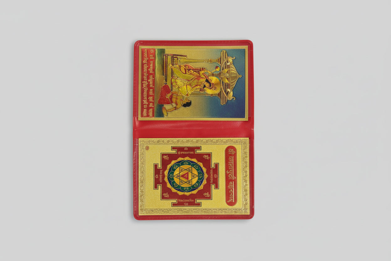 A Yantra or spiritual diagram in red and gold colors, with intricate geometric and decorative patterns, displayed open on a flat surface.