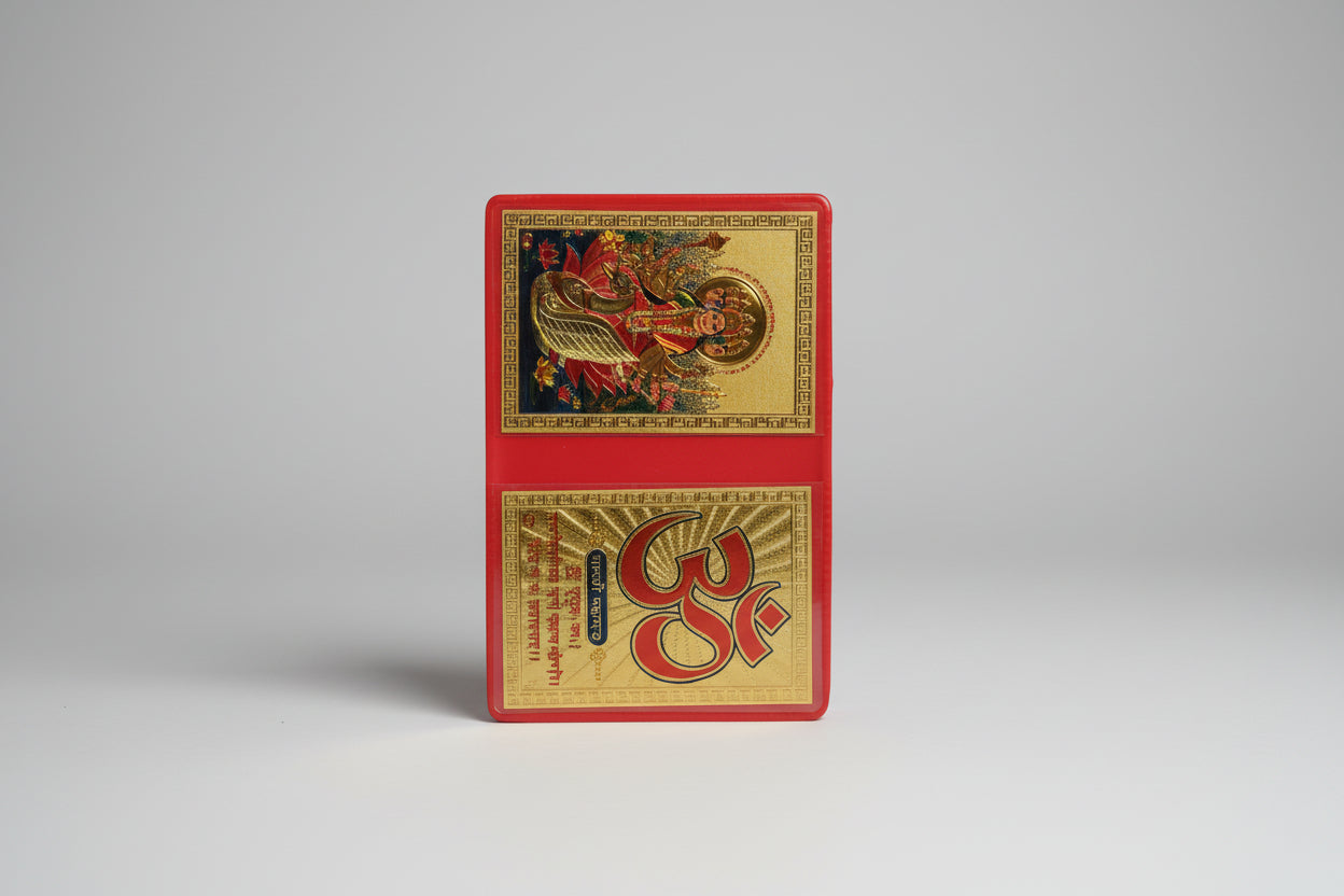 A colorful Yantra or spiritual artwork featuring depictions of deities and geometric patterns, predominantly red and gold.