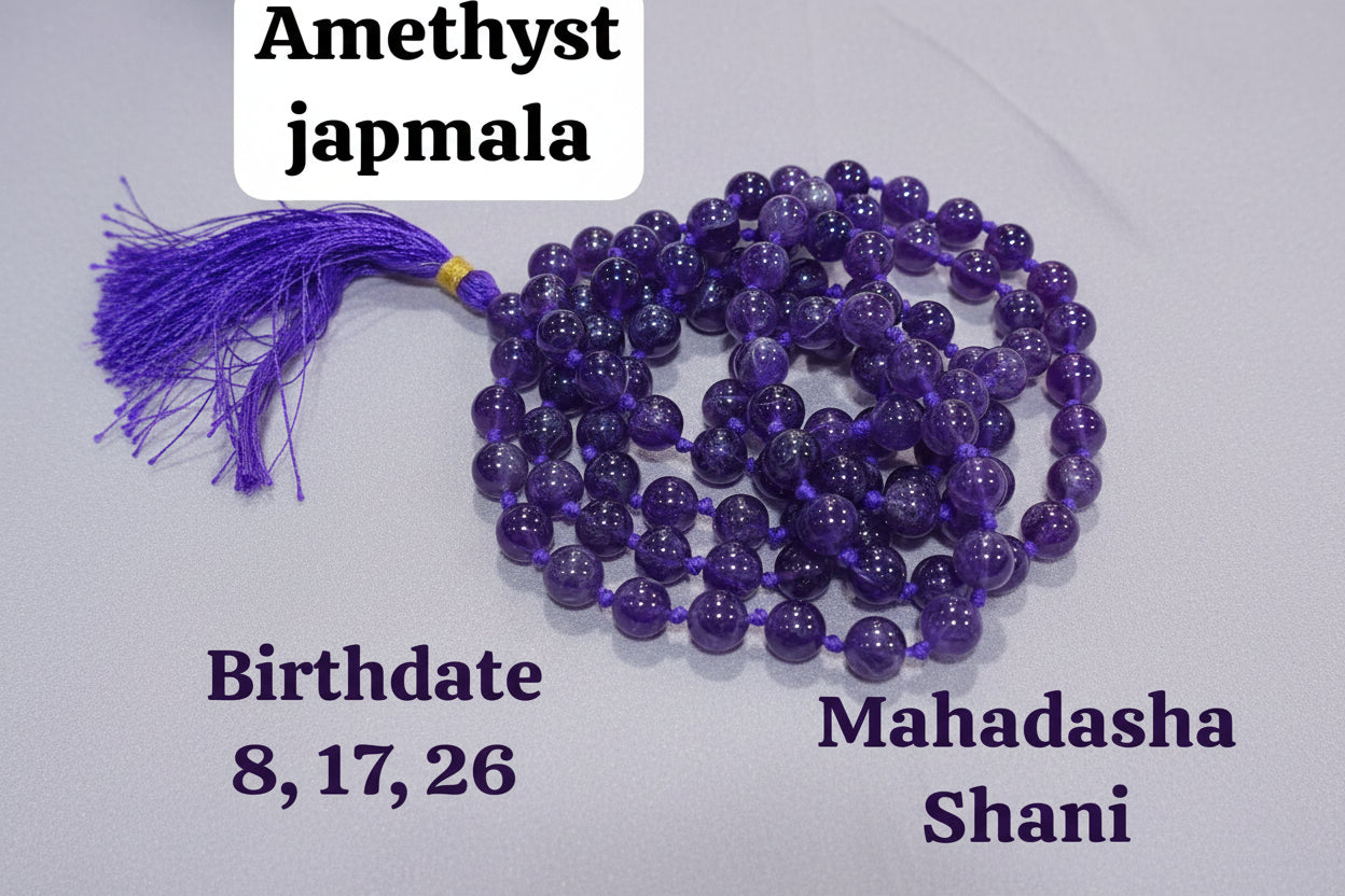 A purple beaded Amethyst Japmala laid out on a red surface, with a decorative tassel at one end. Text on the image indicates birthdates and spiritual properties.