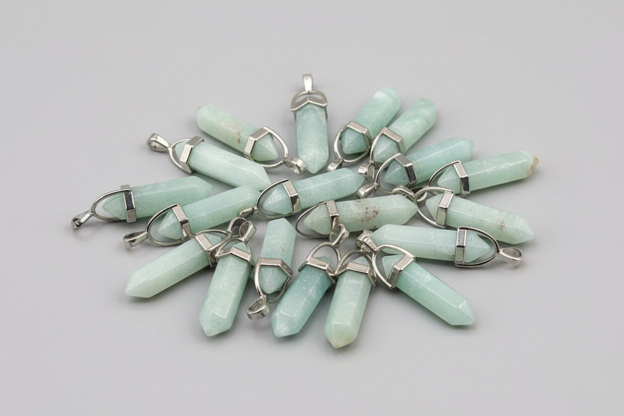 A collection of blue smithsonite pencil pendants with metal loops attached, likely for use as jewelry.