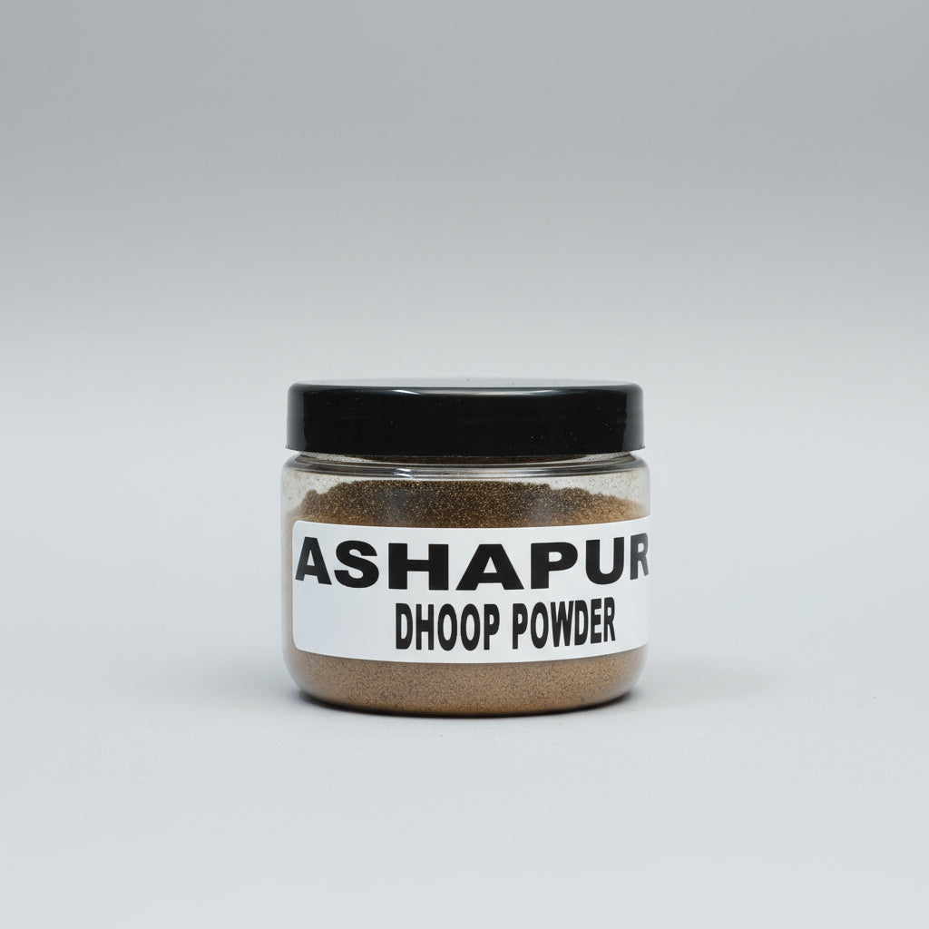 A jar labeled 'ASHAPURI DHOOP POWDER' held in a person's hand, against a red background.