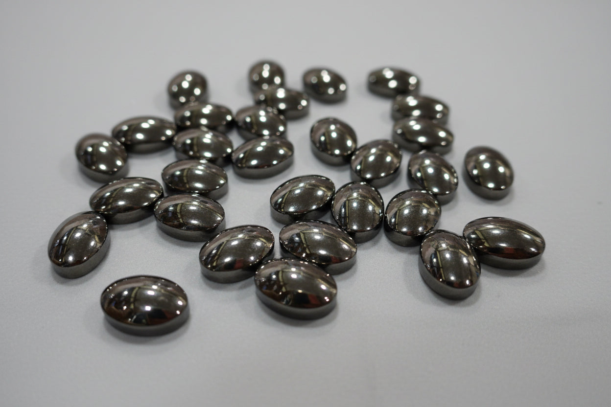 A collection of polished hematite stones displayed on a red surface.
