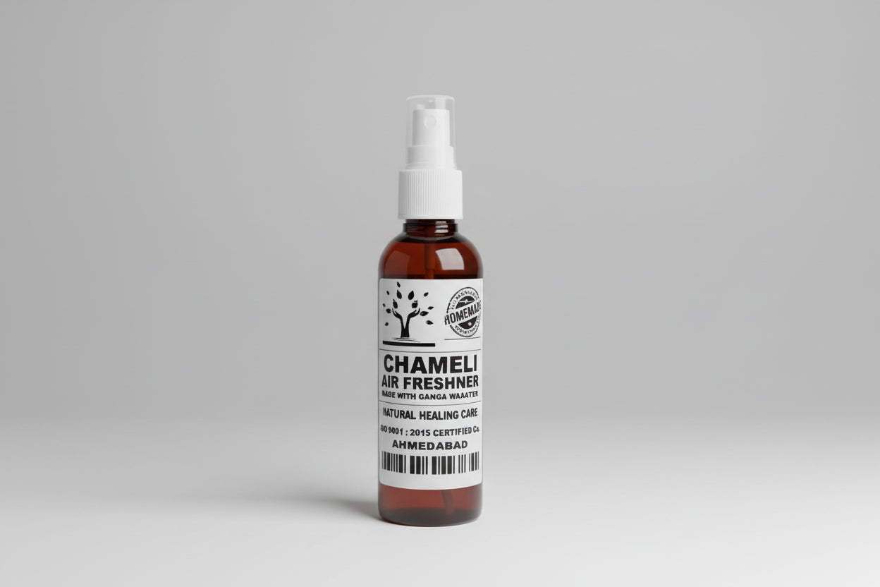 A brown bottle with a white spray nozzle labeled as Chameli Air Freshener, placed on a wooden surface.