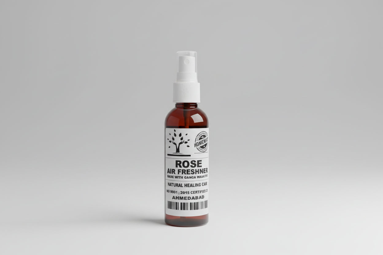 A bottle labeled 'ROSE AIR FRESHENER' with a spray dispenser, placed on a wooden surface.