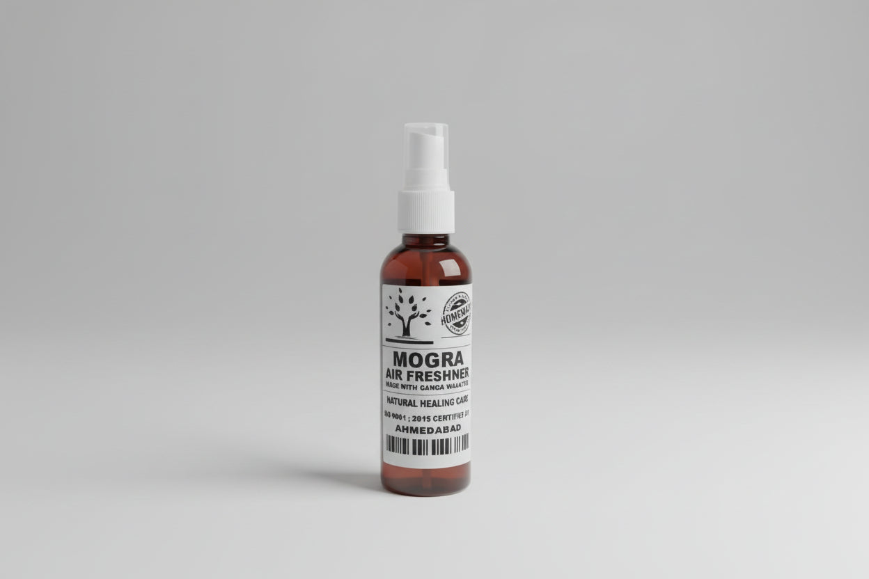 A bottle of Mogra air freshener with a white spray nozzle, placed on a wooden surface.