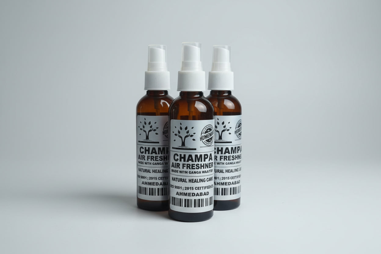 A hand holding a bottle of Champa Air Freshener with another bottle visible in the background, placed in a clear plastic box.