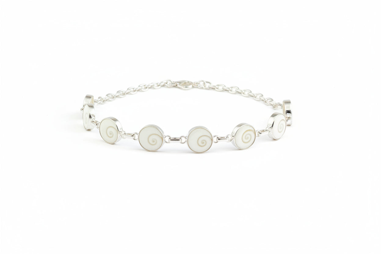 A silver-colored bracelet with multiple circular charms, displayed against a red background.