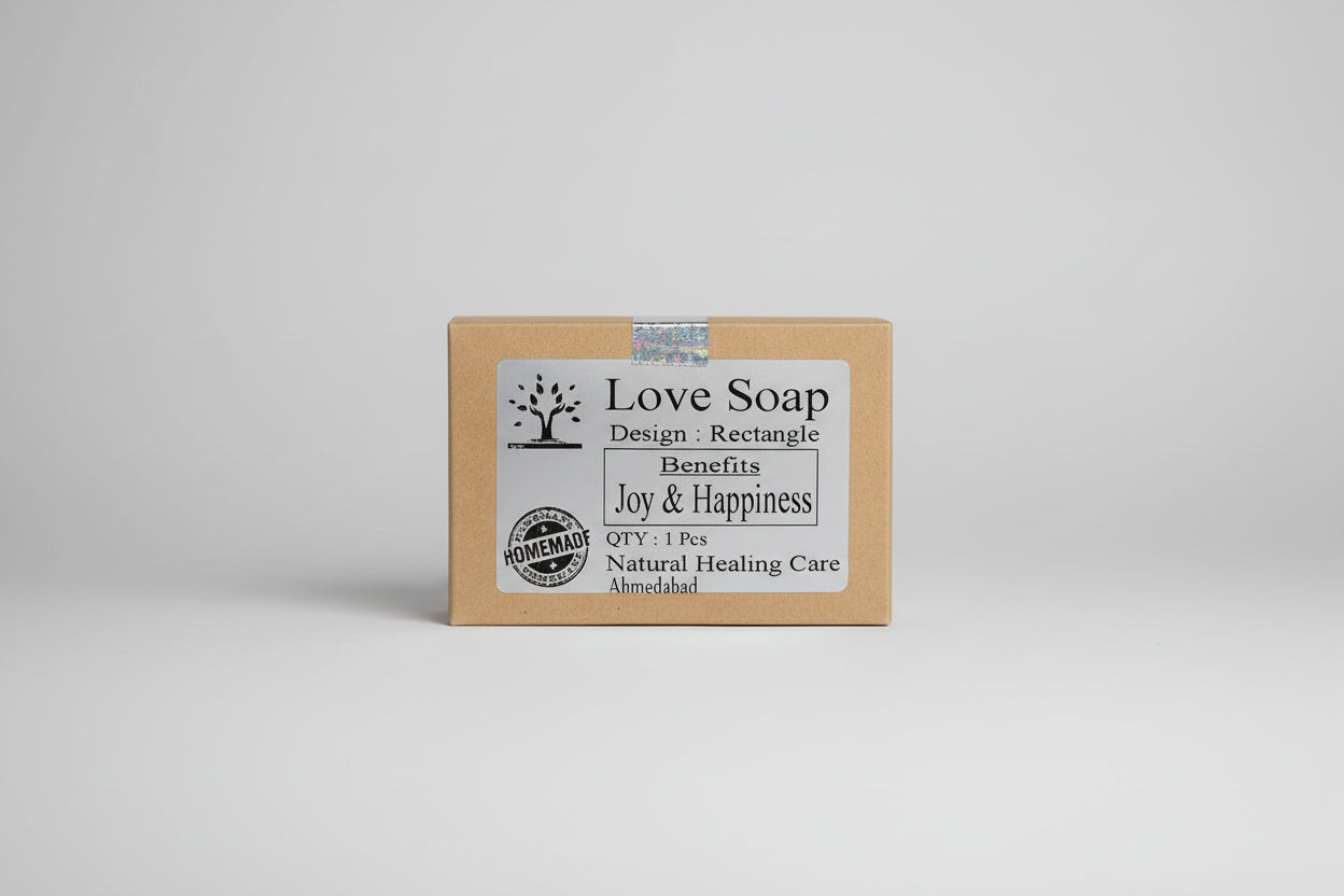 A packaged bar of 'Love Soap' with a label that includes a tree logo and text detailing the benefits such as Joy & Happiness. The packaging indicates it is homemade by Natural Healing Care.
