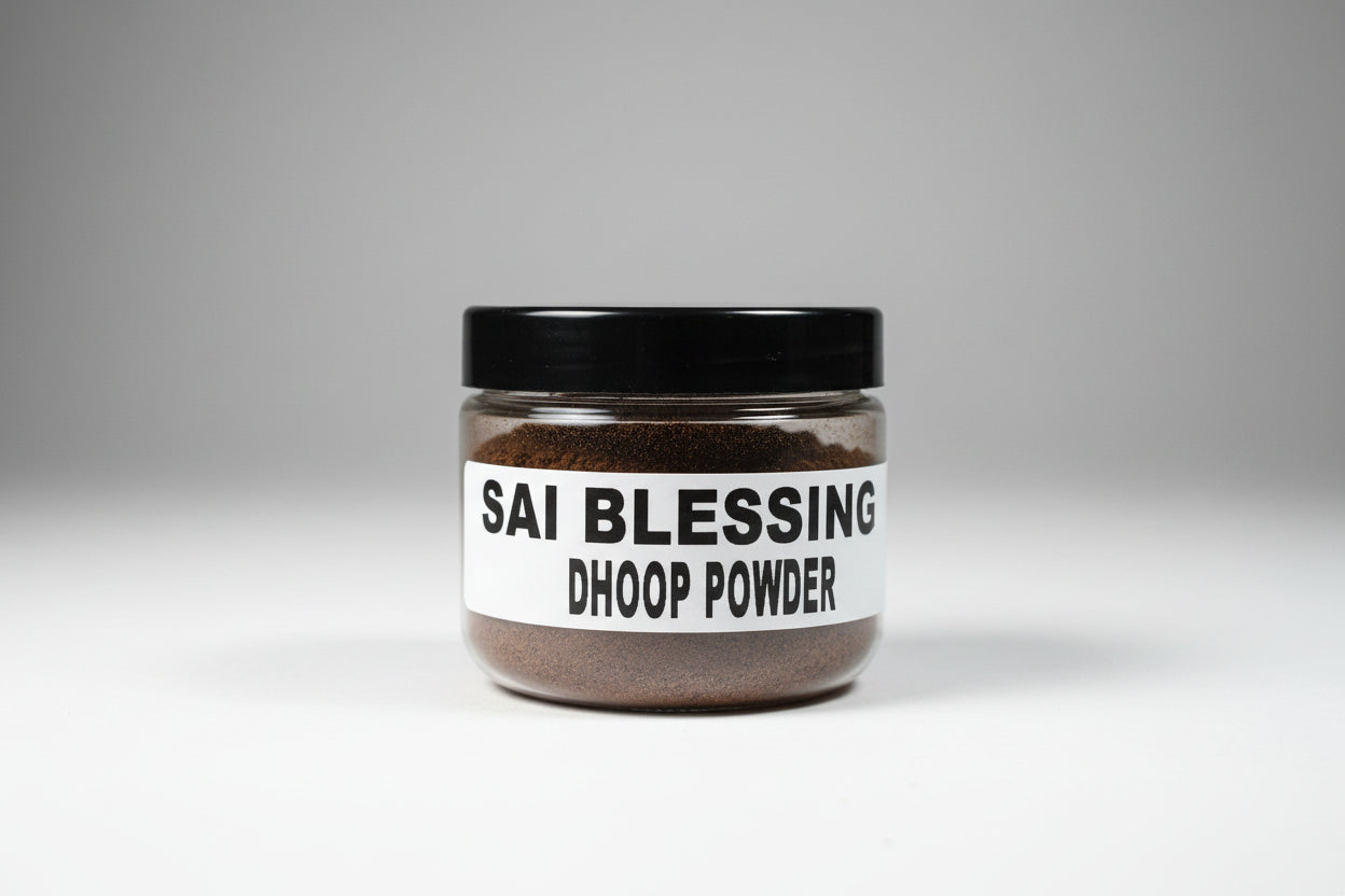 A container labeled 'SAI BLESSING DHOOP POWDER' held in a person's hand against a red background.