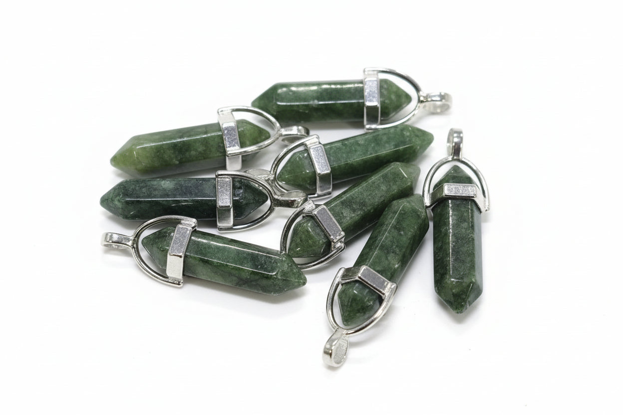 A collection of Nephrite jade pencil-shaped pendants with metal caps at both ends, held in a person's hand.
