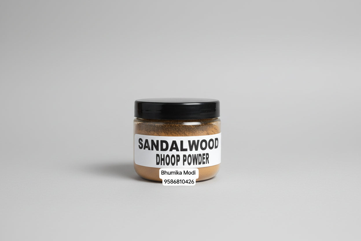A jar labeled Sandalwood Dhoop Powder held in a person's hand against a red background.