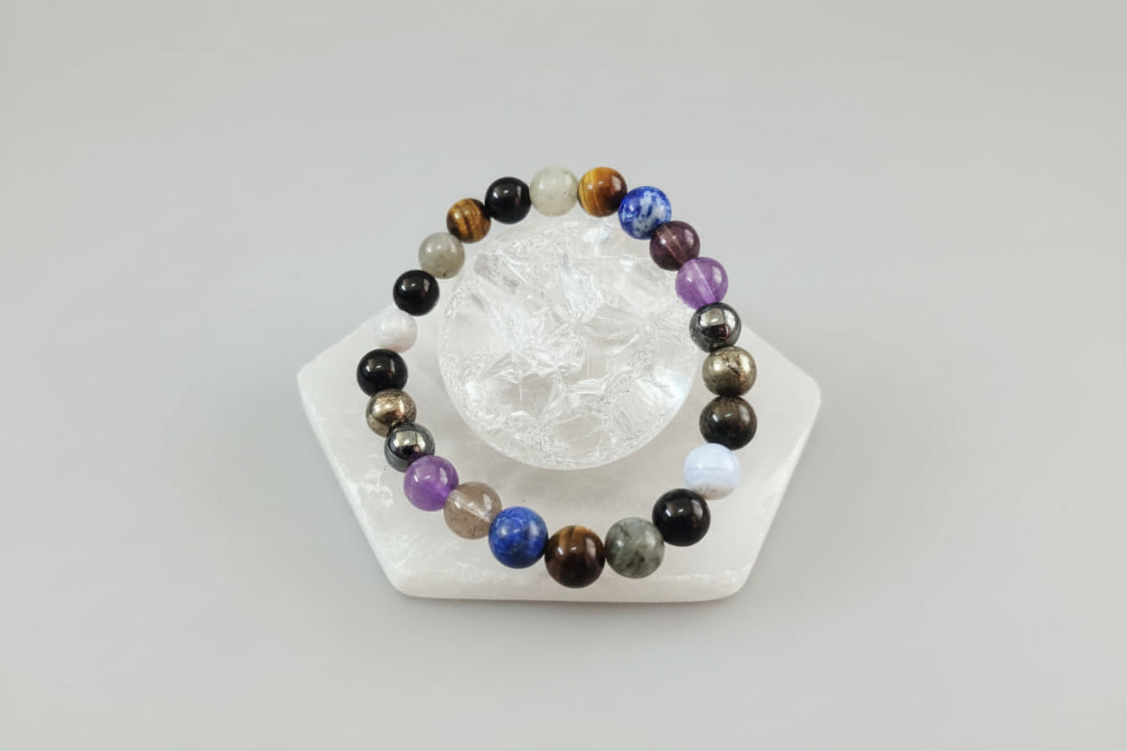 A multicolored beaded bracelet displayed on a white stand, with the bracelet showcasing various colors and patterns.