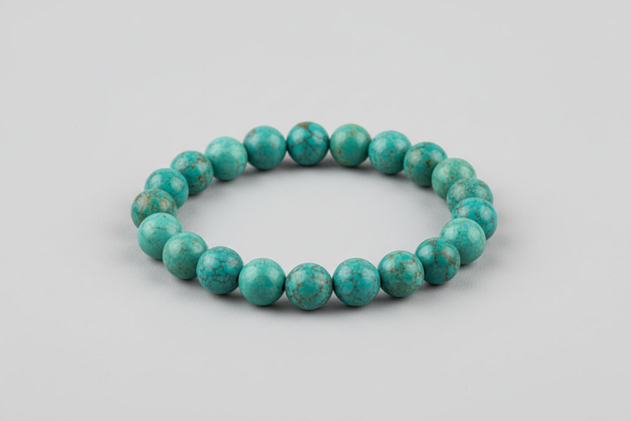 A beaded African Turquoise bracelet displayed on a pink surface with the text highlighting the bracelet's benefits such as luck, success, and prosperity.