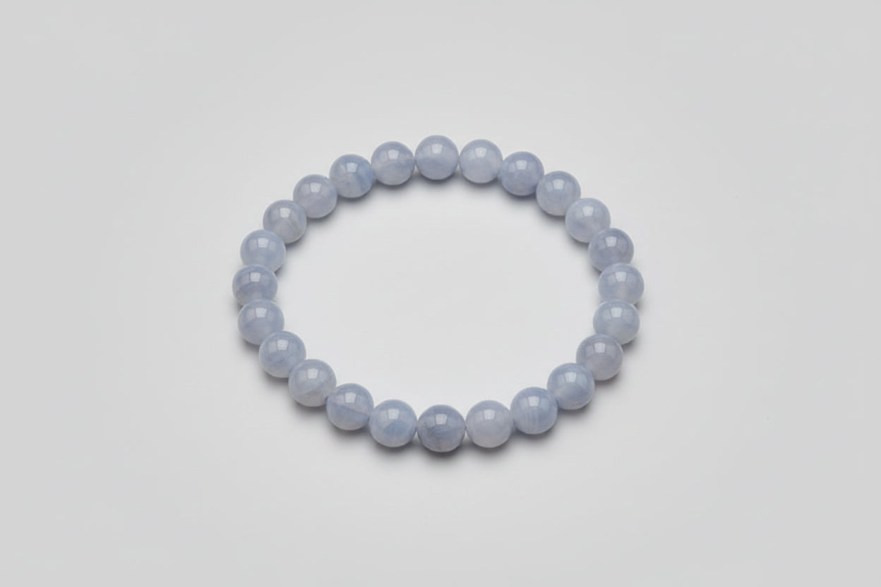 A beaded Blue Lace Agate bracelet displayed on a wooden surface.