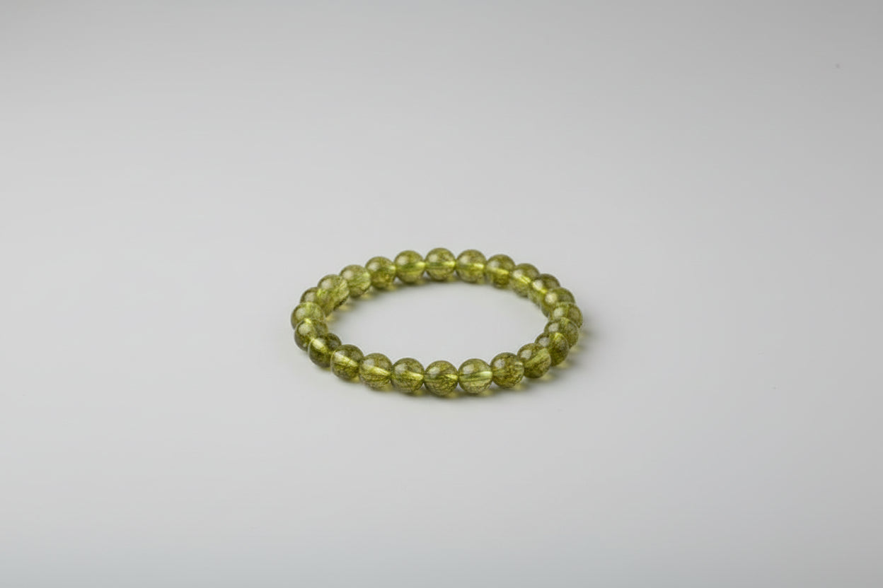 A Peridot bracelet displayed on a white surface with the name 'Bhumika Modi' and a price tag.